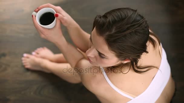 Красивая молодая женщина пьет кофе — стоковое видео