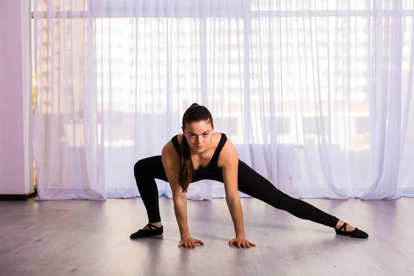 Mujer estirándose en el estudio — Foto de Stock