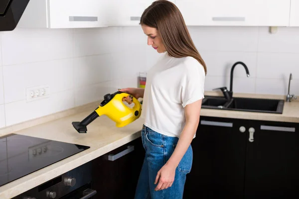 Mulher cozinha de limpeza com aspirador de vapor — Fotografia de Stock