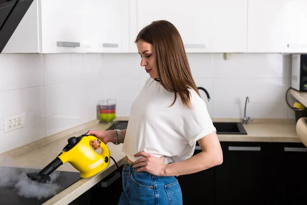 Mulher cozinha de limpeza com aspirador de vapor — Fotografia de Stock