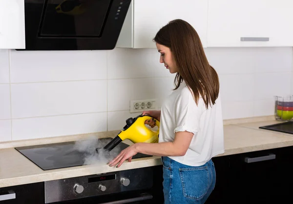 清洗厨房与蒸汽的女人 — 图库照片
