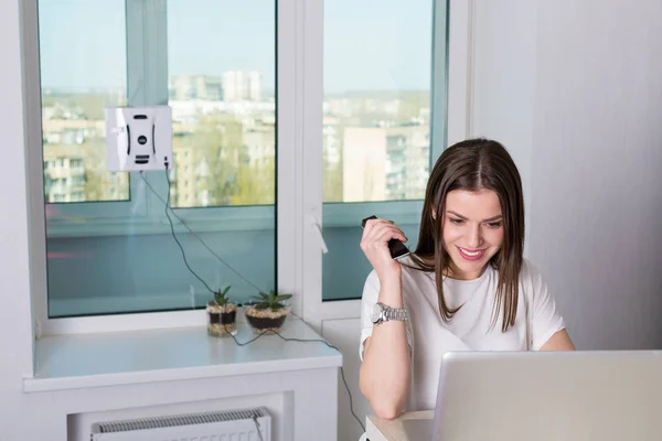 Woman cleaning windows with robotic cleaner — Stock Photo, Image