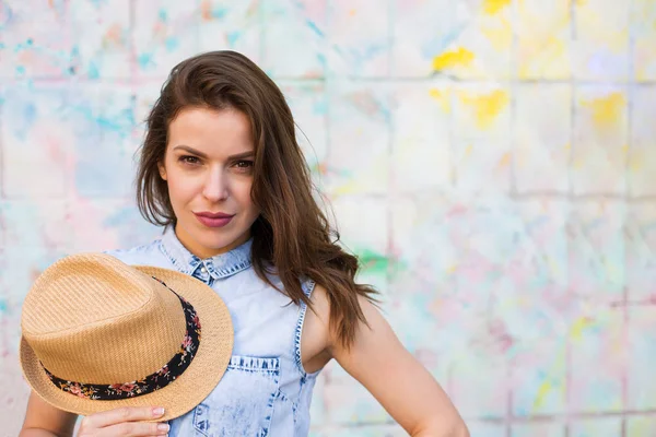 Pretty woman standing against bright painted wall — Stock Photo, Image