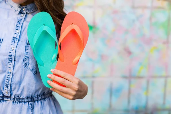 Mujer sosteniendo sandalias chanclas brillantes —  Fotos de Stock