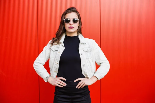 Mujer con estilo de pie cerca de la pared roja —  Fotos de Stock