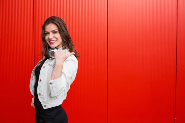 Stijlvolle vrouw stond in de buurt van de rode muur — Stockfoto