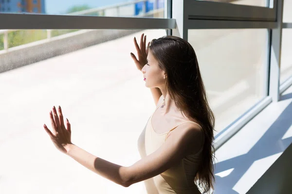 Молодая женщина сидит у окна — стоковое фото