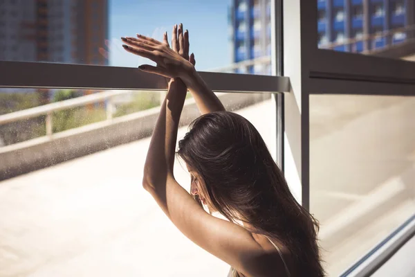 Ung kvinna sitter vid fönstret — Stockfoto