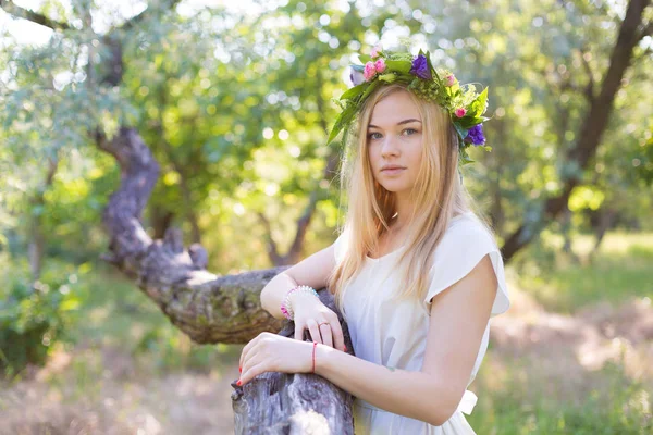 Schöne junge Frau im Blumenkranz — Stockfoto