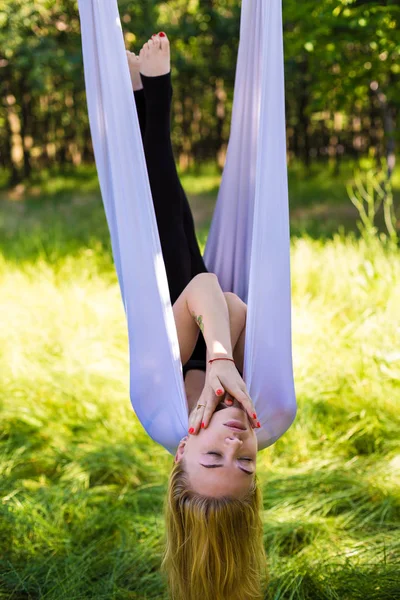 Woman in aerial yoga hammock