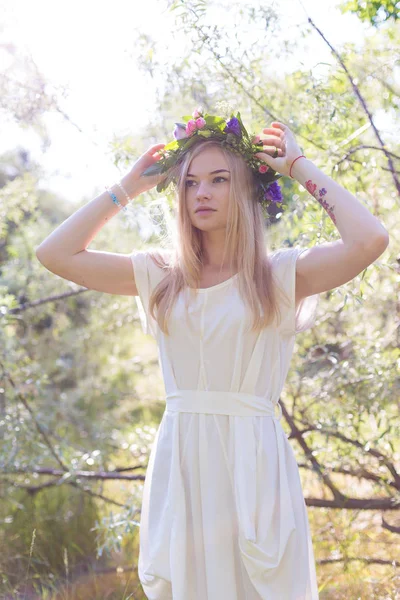 Schöne junge Frau im Blumenkranz — Stockfoto