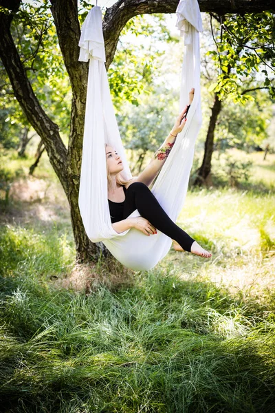 Kvinde i antenne yoga hængekøje - Stock-foto