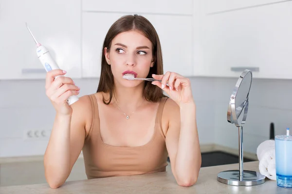 Woman with toothbrush and oral irrigator — Stock Photo, Image