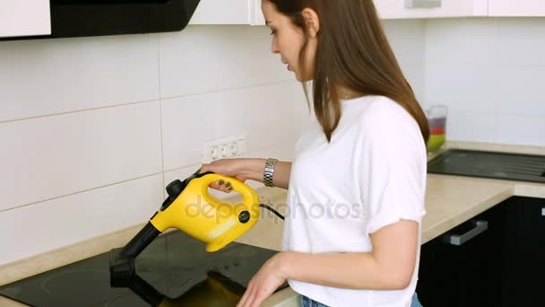 Женщина чистит кухню с пароочистителем — стоковое видео