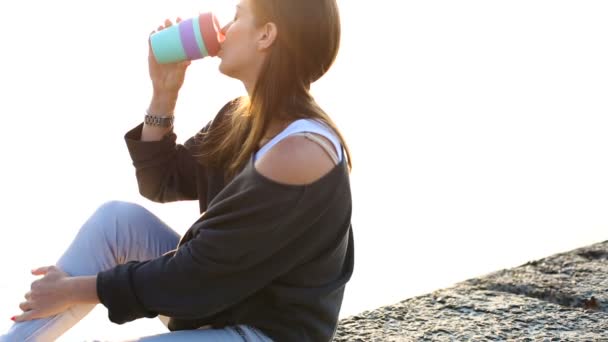 Kvinna som dricker kaffe på stranden — Stockvideo
