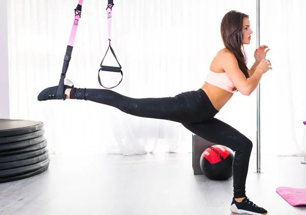 Mulher exercitando-se com tiras no ginásio — Fotografia de Stock