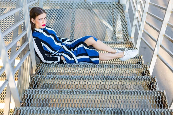 Metal merdivenlerde oturan kadın