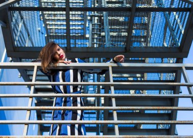 Metal merdivenlerde oturan kadın