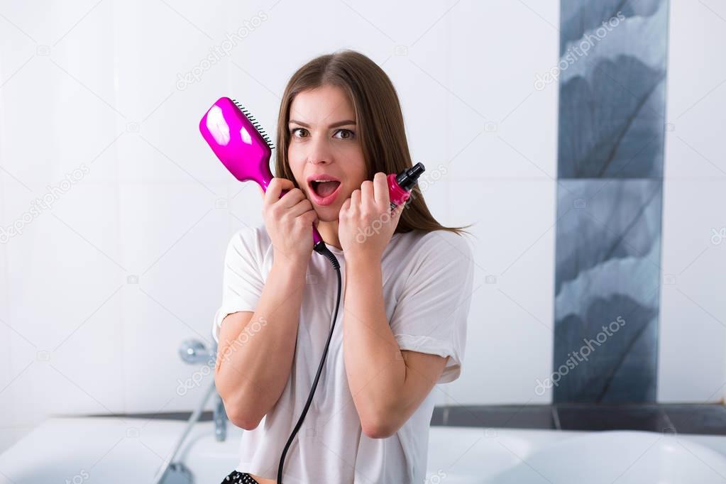Woman with a hot straightening brush