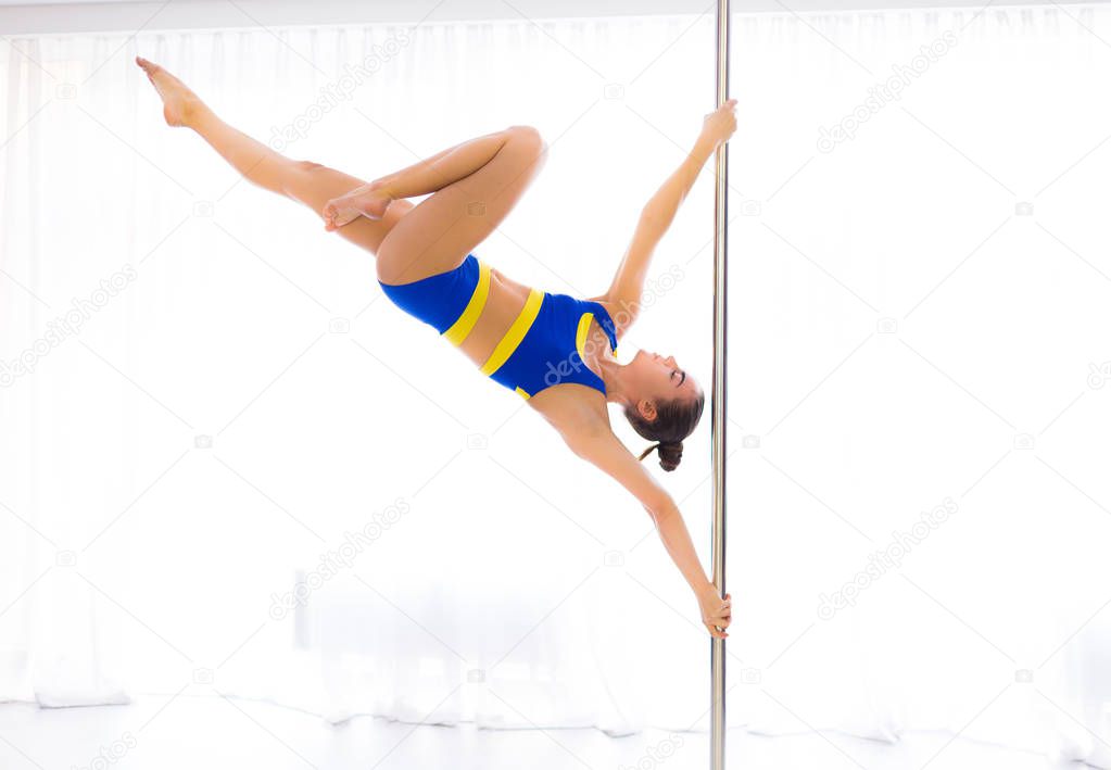 Young pole dancer in the studio