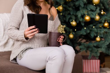 Kadın e-kitap Noel ağacı yakınındaki okuma