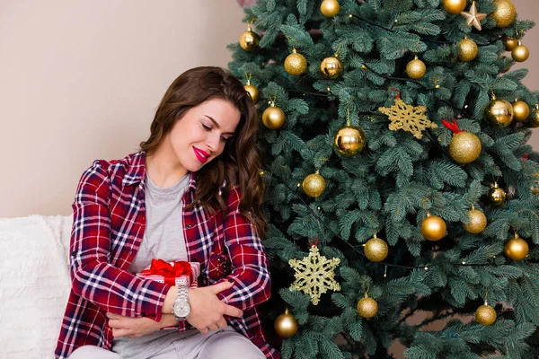 Woman sitting near the Christmas tree — Stock Photo, Image