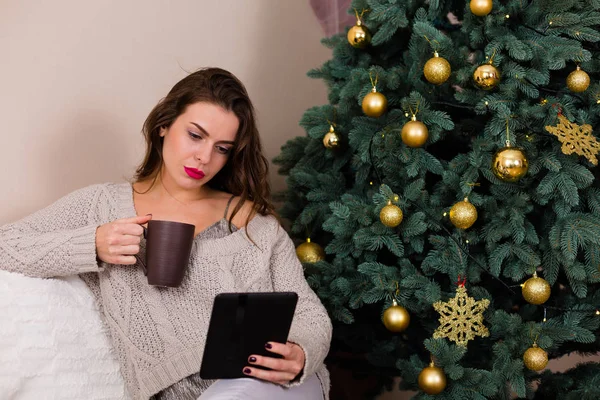 크리스마스 트리 근처 전자-책을 읽는 여자 — 스톡 사진