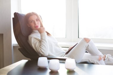 Kadın e-kitap pencerenin yanındaki okuma