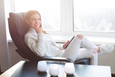 Kadın e-kitap pencerenin yanındaki okuma