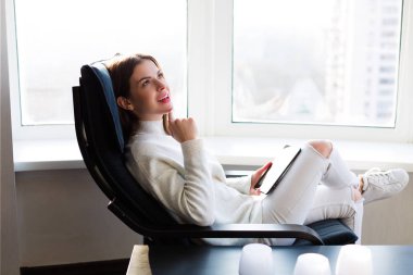 Kadın e-kitap pencerenin yanındaki okuma