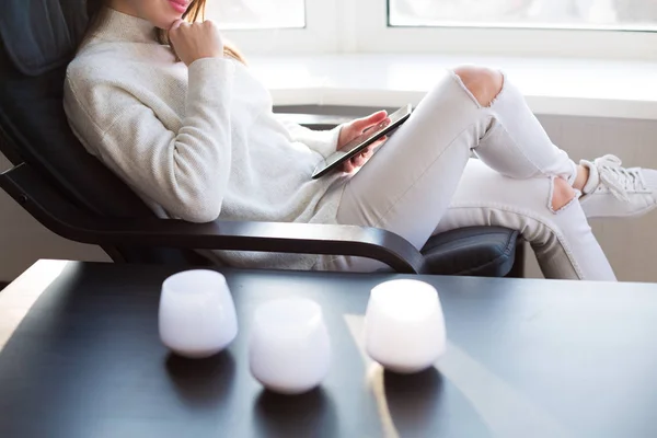 Woman reading e-book by the window — Stock Photo, Image