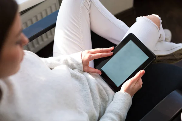 Woman reading e-book by the window — Stock Photo, Image