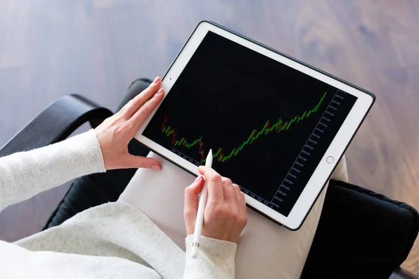 Woman holding a tablet with cryptocurrency logos