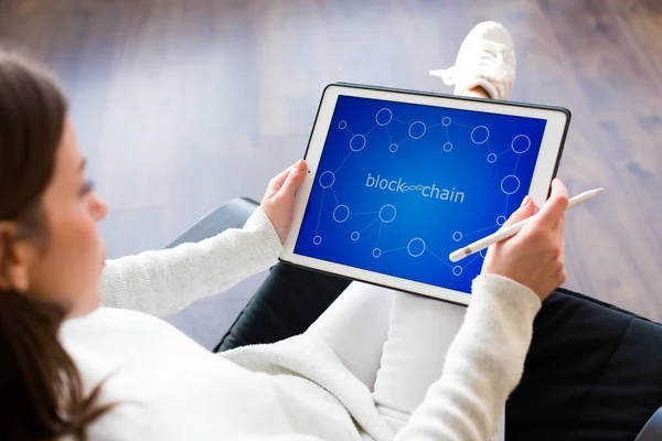 Woman holding a tablet with cryptocurrency logos