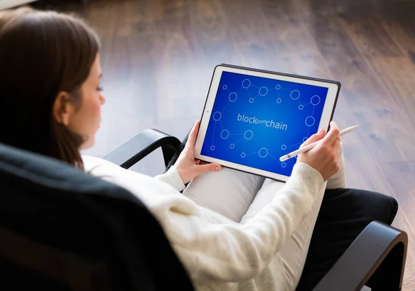 Woman holding a tablet with cryptocurrency logos