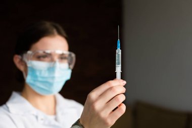 kadın doktor bir şırınga tutarak