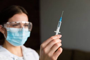 kadın doktor bir şırınga tutarak