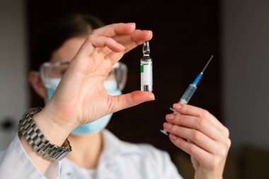 kadın doktor bir şırınga tutarak