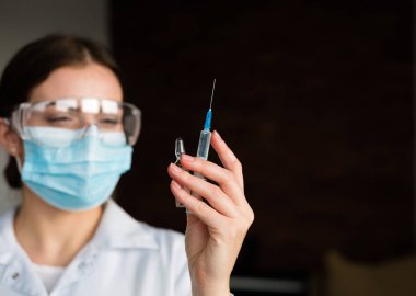 kadın doktor bir şırınga tutarak