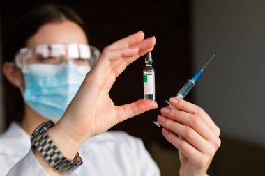 kadın doktor bir şırınga tutarak
