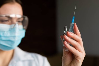 kadın doktor bir şırınga tutarak
