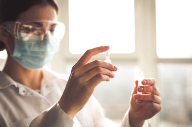 Kadın antibiyotik örnekleri ve şırınga tutarak laboratorian