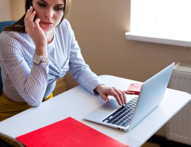 Belgili tanımlık laptop, ofiste çalışan genç kadın