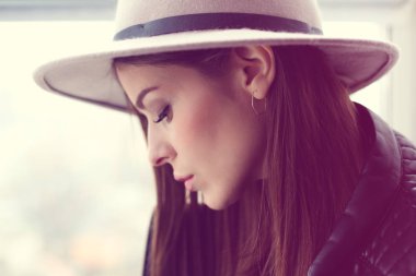 Cam kenarında oturan yün şapka kadında güzel boho