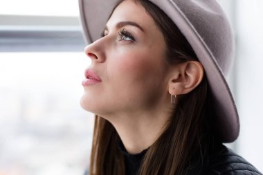 Cam kenarında oturan yün şapka kadında güzel boho