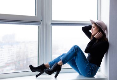 Cam kenarında oturan yün şapka kadında güzel boho