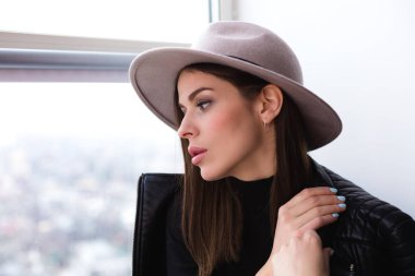 Cam kenarında oturan yün şapka kadında güzel boho