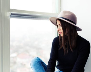 Cam kenarında oturan yün şapka kadında güzel boho