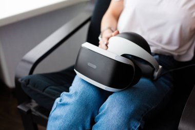 Bir Vr kulaklık tutan genç kadın