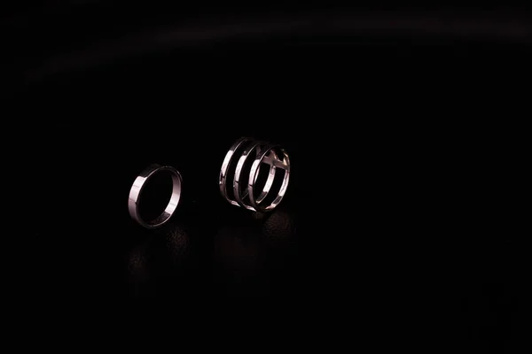 Fine silver jewelry on a black background with copy space
